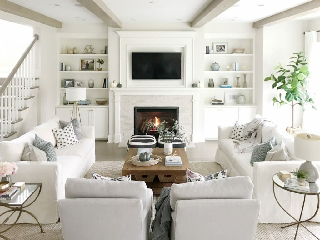 open concept, living room, neutral decor, white couches, white sofa, builtins fireplace, tv above fireplace, living room beams