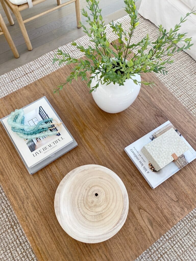 Square wooden coffee table with coffee table books, box and bowl 