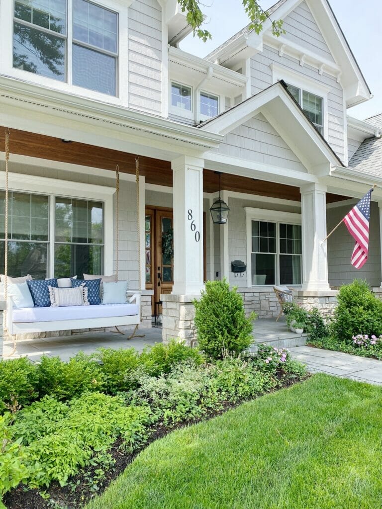 Bluestone front porch with wooden hanging porch swing, house painted in Benjamin Moore smoke embers.