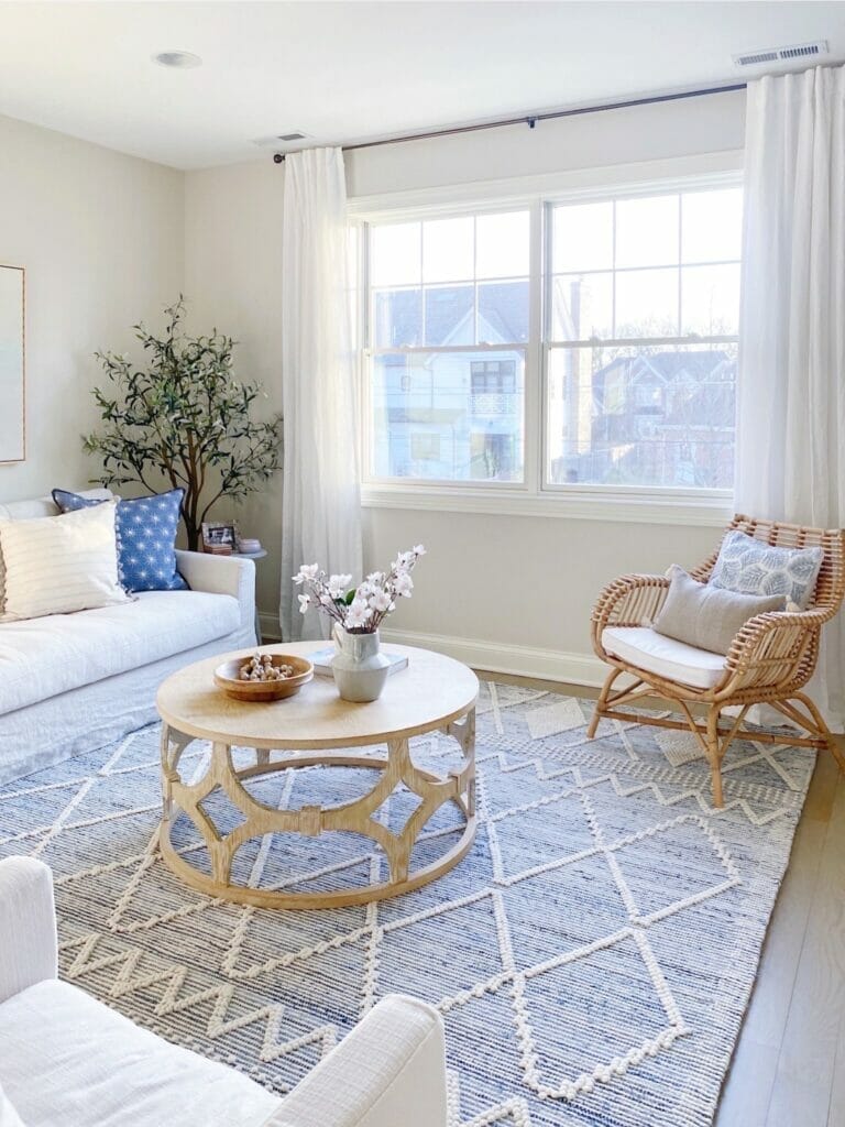 living room features Serena & Lily Ryder denim rug, and rattan accent chair