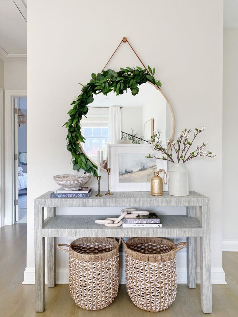 Serena & Lily Black console table in fog, round mirror from west elm with garland detailing, and Christmas table styling