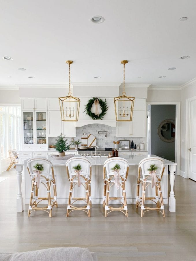 serena and lily riviera counter stools in white, brass lantern fixtures, marble subway backsplash, and festive Christmas touches | Your Black Friday Shopping Guide 2021