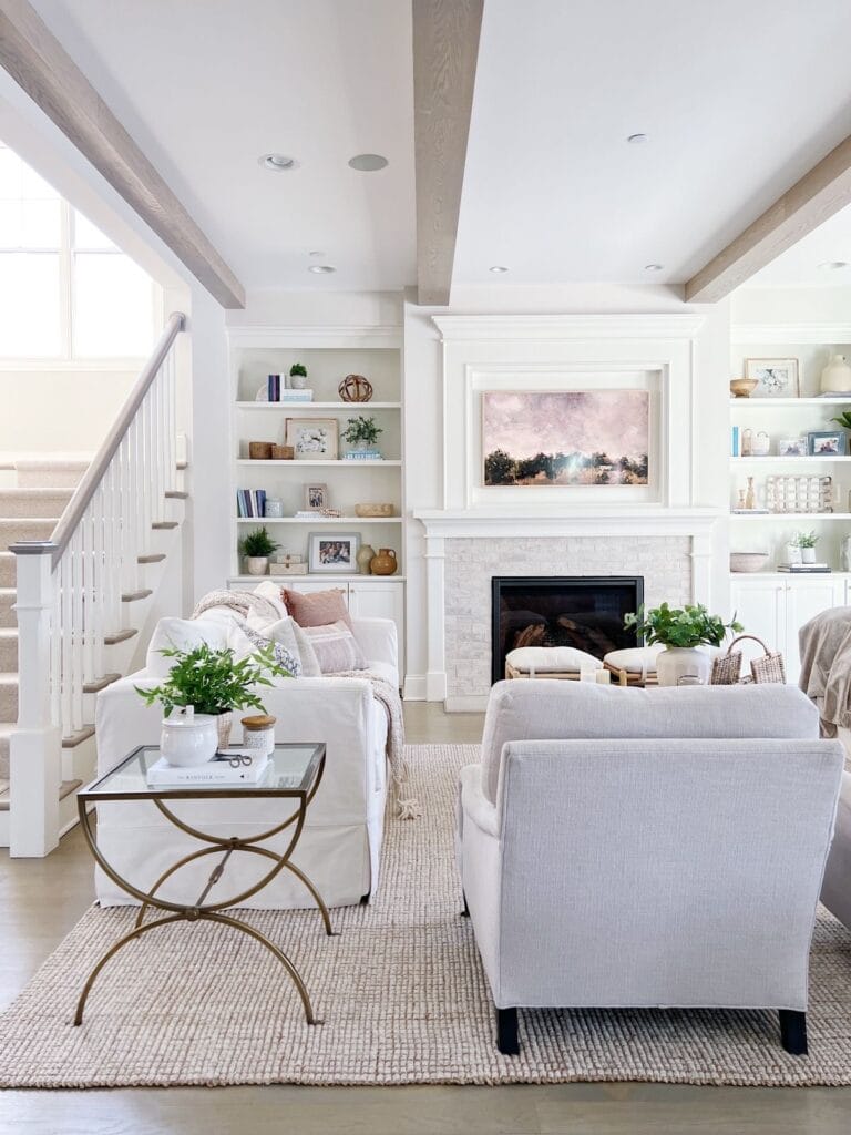 white living room with wood beam, white sofa and chairs